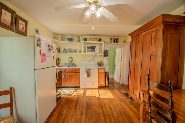 kitchen featuring a wall mounted air conditioner, ceiling fan, light wood-type flooring, and white appliances