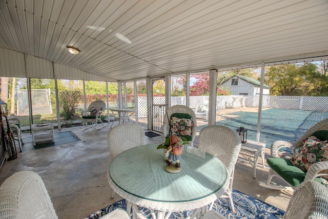 sunroom / solarium featuring lofted ceiling and a healthy amount of sunlight