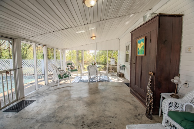 unfurnished sunroom featuring vaulted ceiling and wood ceiling