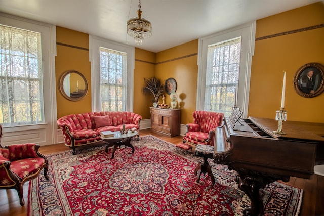 living area with a notable chandelier, hardwood / wood-style flooring, and plenty of natural light