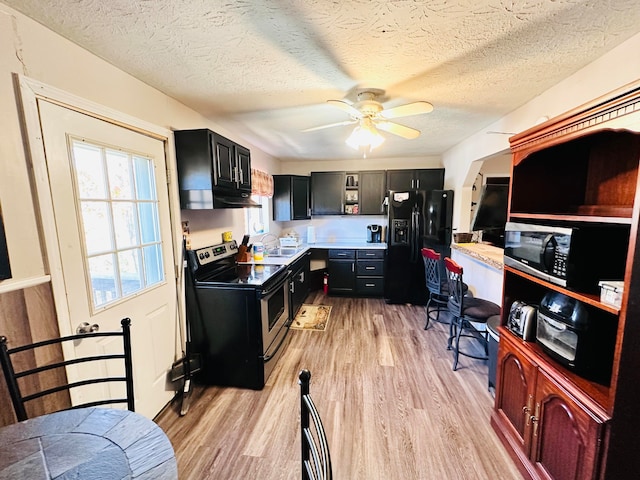 kitchen with sink, a textured ceiling, light hardwood / wood-style floors, stainless steel appliances, and ceiling fan