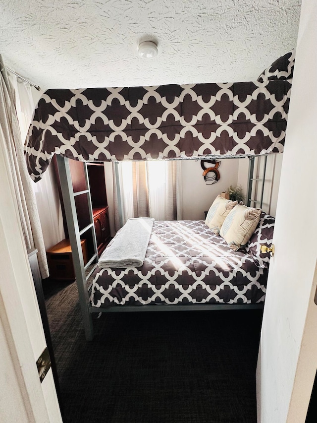 bedroom featuring a textured ceiling and carpet