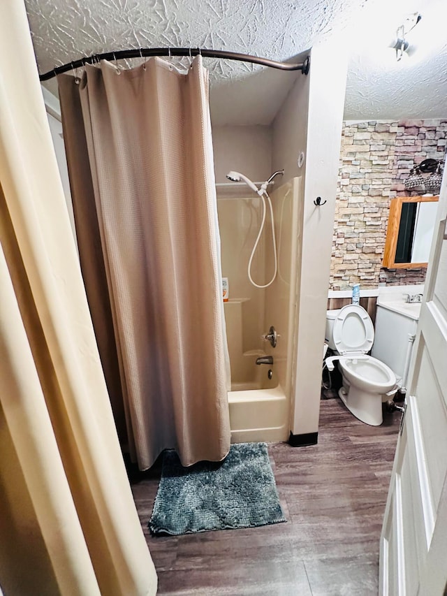 full bathroom with toilet, shower / tub combo, wood-type flooring, vanity, and a textured ceiling