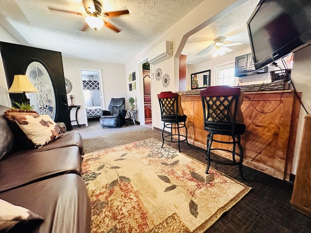 living room with a wall mounted air conditioner, a textured ceiling, dark carpet, and ceiling fan