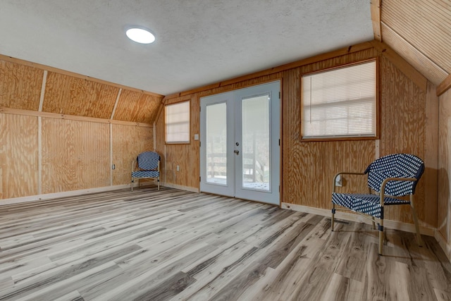 unfurnished room featuring light hardwood / wood-style flooring, vaulted ceiling, and a wealth of natural light