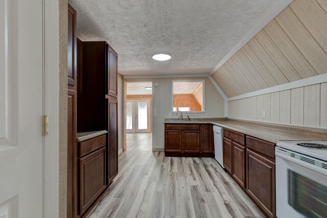 kitchen with vaulted ceiling, light hardwood / wood-style flooring, french doors, sink, and white appliances