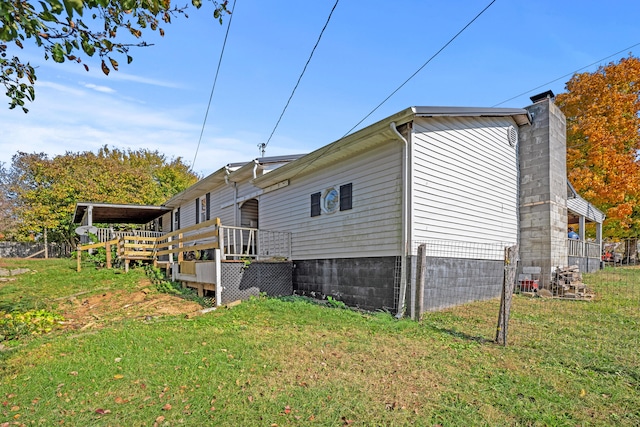 view of home's exterior featuring a wooden deck and a yard