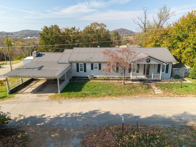 view of front of home with a mountain view, a porch, and a front lawn