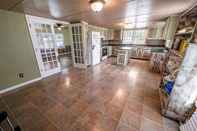 kitchen featuring ceiling fan, a breakfast bar, french doors, sink, and white appliances