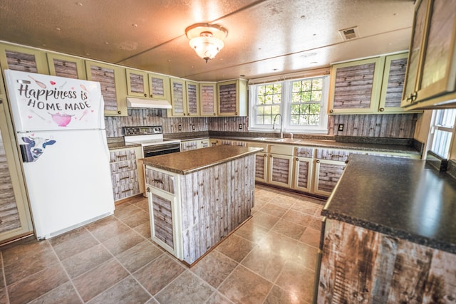 kitchen featuring sink, a textured ceiling, a center island, electric range, and white fridge