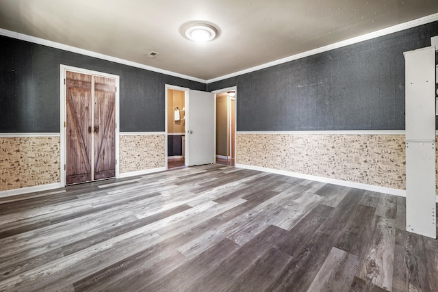 spare room with ornamental molding and wood-type flooring