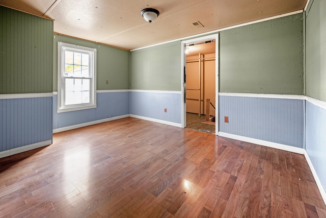 spare room with wooden walls and hardwood / wood-style floors