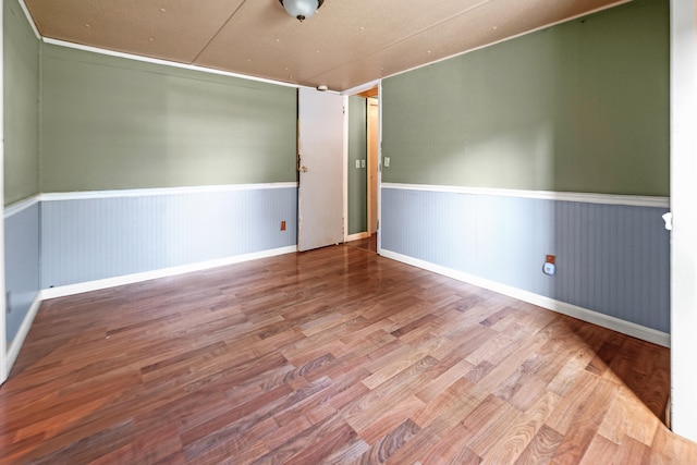 unfurnished room featuring wood-type flooring and wooden walls