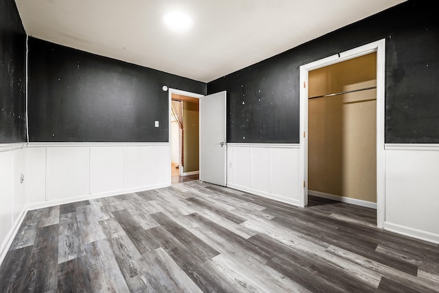 unfurnished bedroom with wood-type flooring and a closet