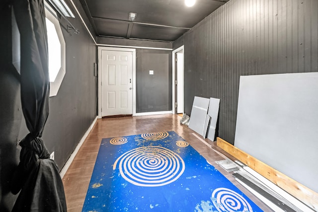 entryway featuring dark wood-type flooring and wooden walls