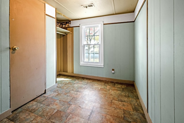 unfurnished bedroom featuring wood walls