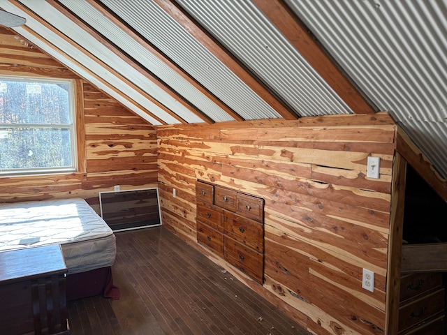 unfurnished bedroom with vaulted ceiling, dark hardwood / wood-style flooring, and wood walls