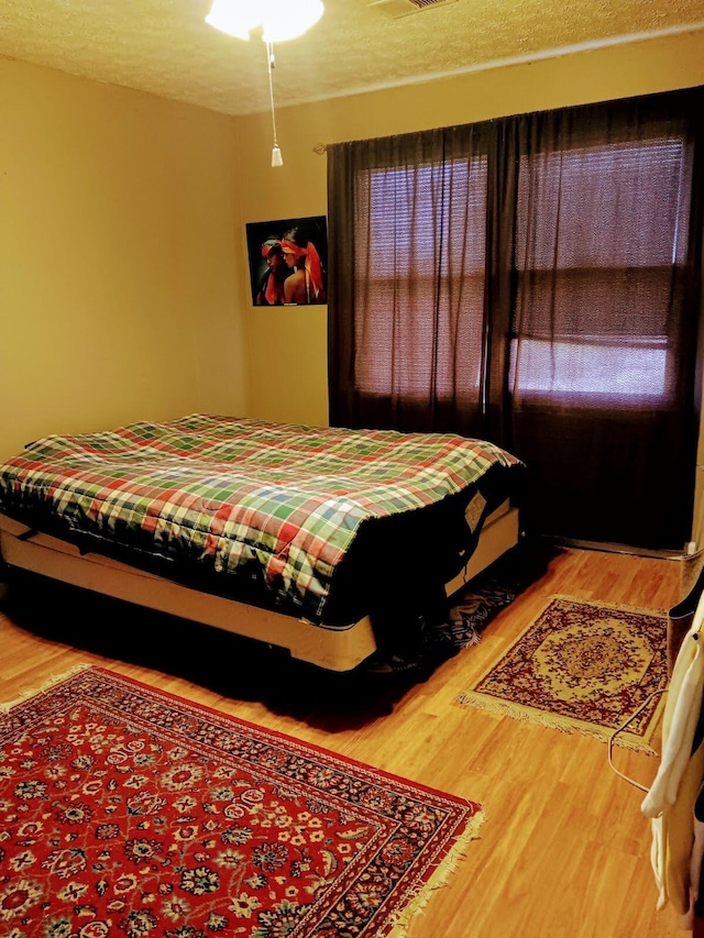 bedroom featuring a textured ceiling and hardwood / wood-style flooring