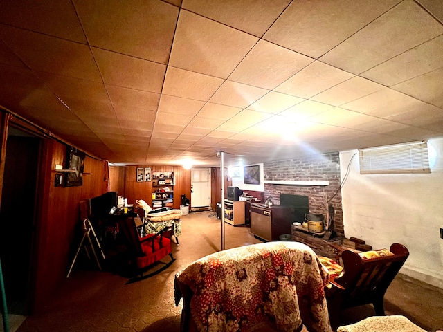 interior space with carpet floors, wooden walls, and a brick fireplace