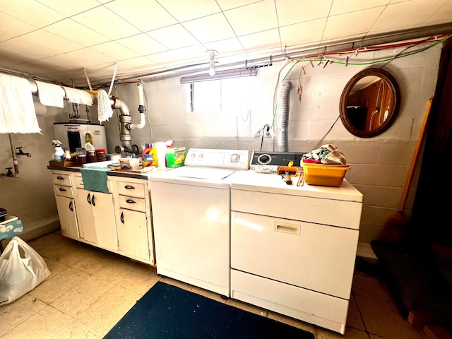 laundry room with sink, electric water heater, washing machine and dryer, and cabinets