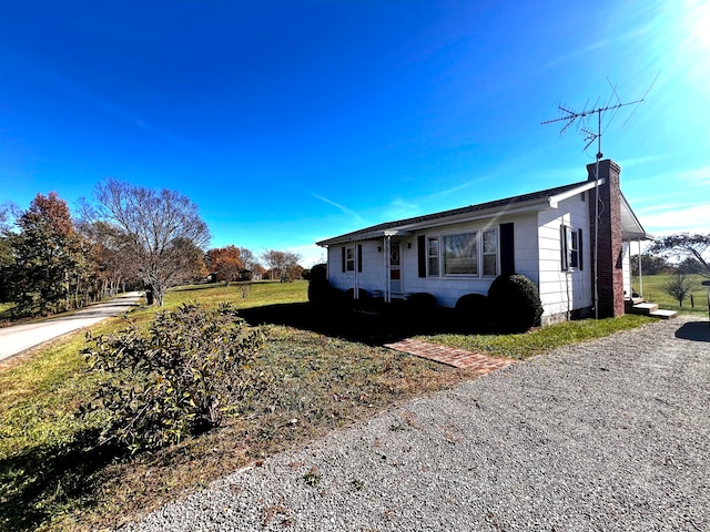 view of side of home with a yard