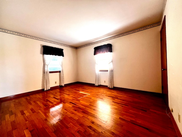 spare room featuring wood-type flooring and ornamental molding