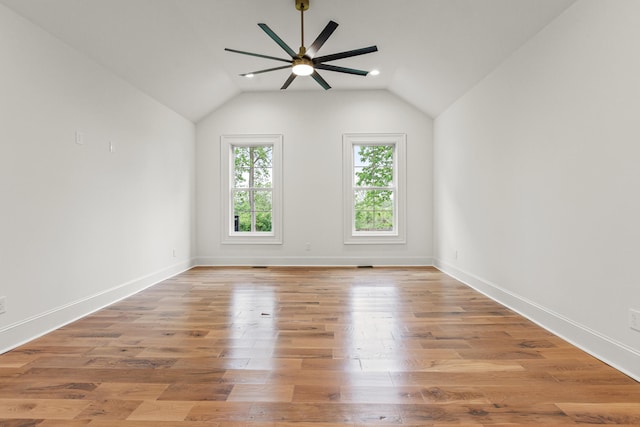 empty room with lofted ceiling, hardwood / wood-style floors, and ceiling fan