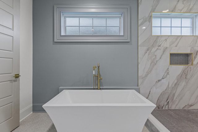 bathroom featuring sink and a tub to relax in