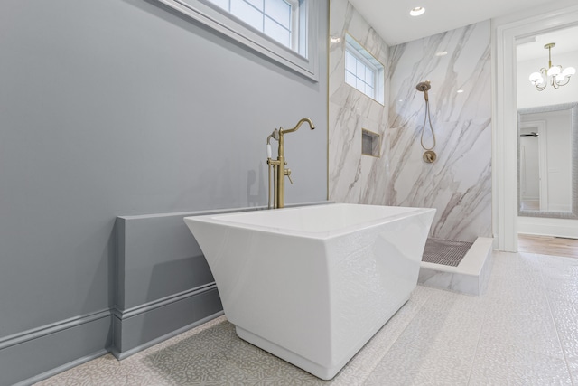 bathroom featuring independent shower and bath and an inviting chandelier