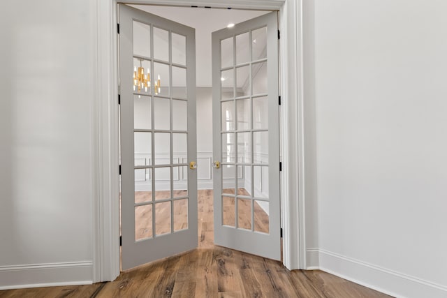 doorway to outside with hardwood / wood-style floors, a chandelier, and french doors