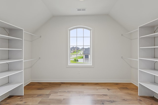 spacious closet with lofted ceiling and light hardwood / wood-style flooring