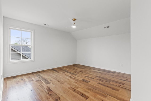 spare room featuring lofted ceiling, light wood-type flooring, and ceiling fan