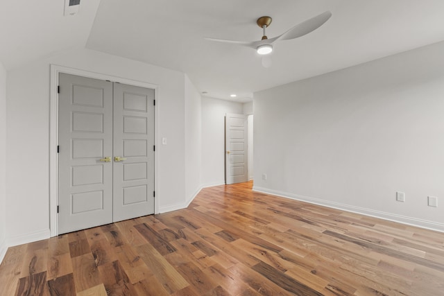 unfurnished bedroom with a closet, vaulted ceiling, light hardwood / wood-style floors, and ceiling fan