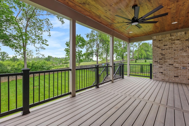 wooden terrace featuring a yard and ceiling fan