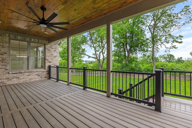 wooden deck featuring a lawn and ceiling fan