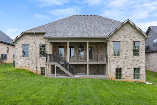 rear view of property with a lawn and ceiling fan