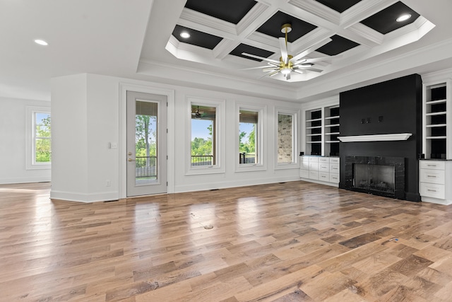 unfurnished living room with coffered ceiling, light hardwood / wood-style floors, and plenty of natural light