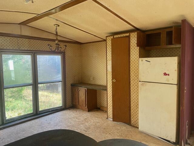 kitchen featuring white fridge and vaulted ceiling