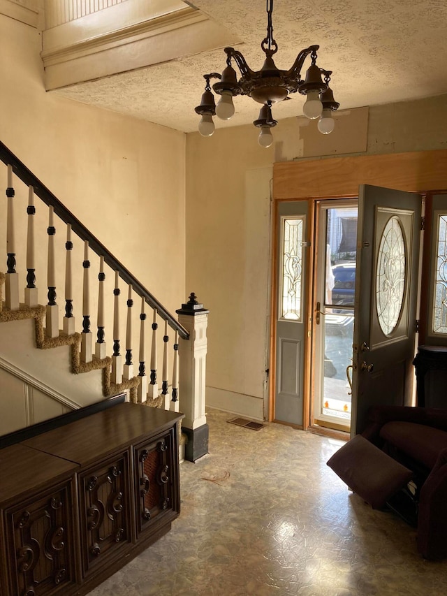 entryway with a notable chandelier, a healthy amount of sunlight, and a textured ceiling