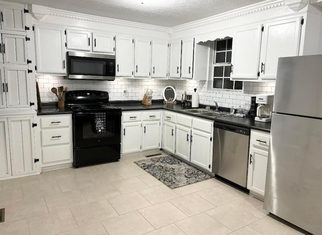 kitchen with stainless steel appliances, sink, light tile patterned floors, a textured ceiling, and tasteful backsplash