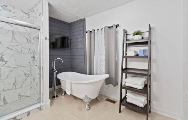 bathroom with tile patterned floors, plus walk in shower, and a textured ceiling