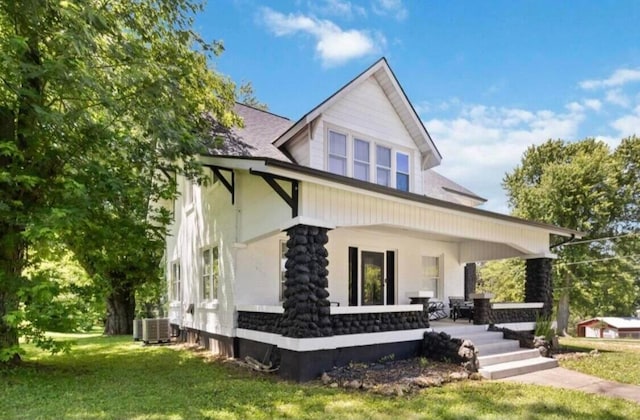 view of front facade featuring cooling unit and a front yard