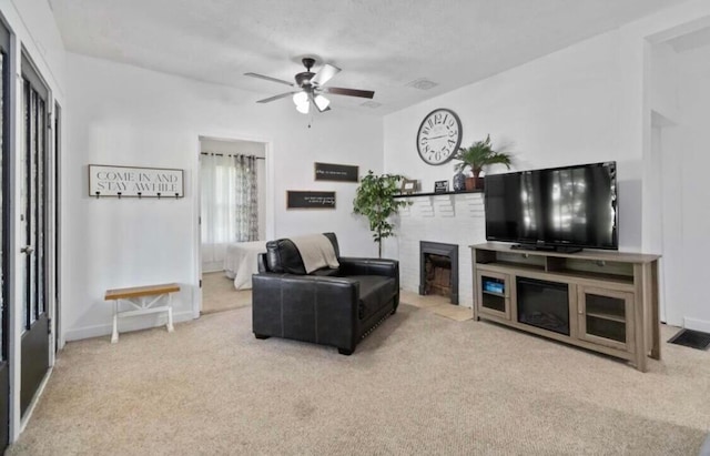 living room with carpet, a brick fireplace, and ceiling fan