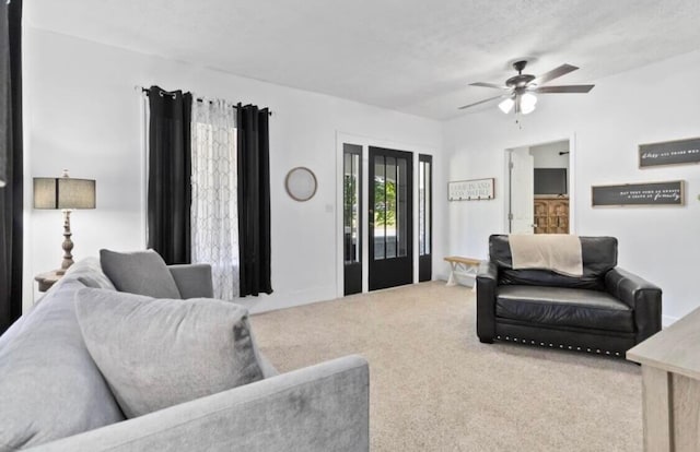 carpeted living room featuring a textured ceiling and ceiling fan