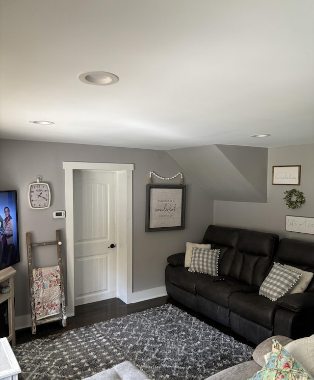 living room with vaulted ceiling and dark wood-type flooring