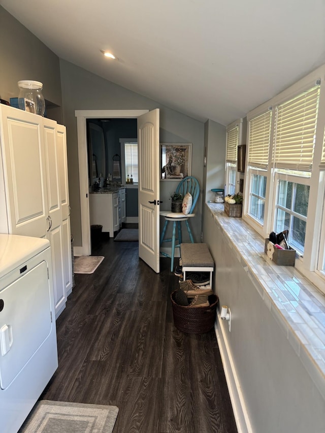 interior space featuring vaulted ceiling, washer / dryer, and dark hardwood / wood-style flooring