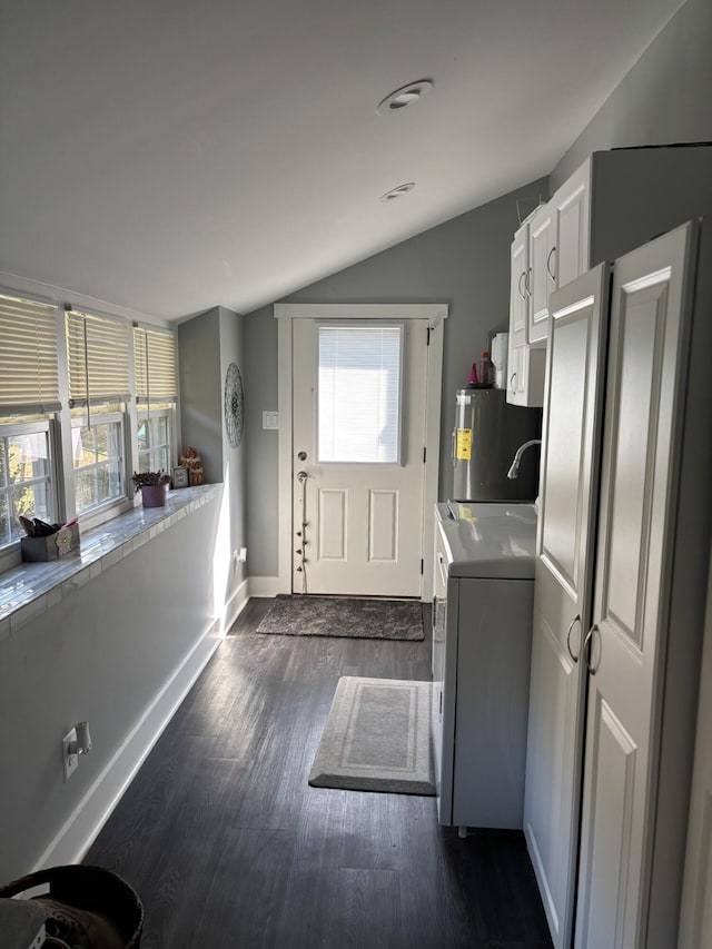 kitchen featuring vaulted ceiling, a wealth of natural light, water heater, washer / clothes dryer, and white cabinets