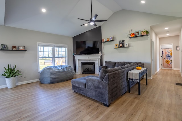 living room featuring high vaulted ceiling, light hardwood / wood-style floors, and ceiling fan