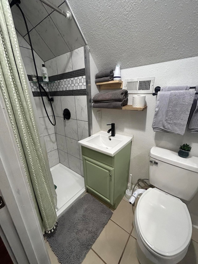 bathroom with toilet, vanity, tile patterned floors, and walk in shower