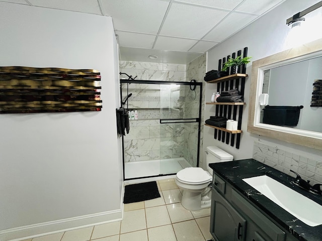 bathroom featuring tasteful backsplash, walk in shower, vanity, tile patterned flooring, and toilet